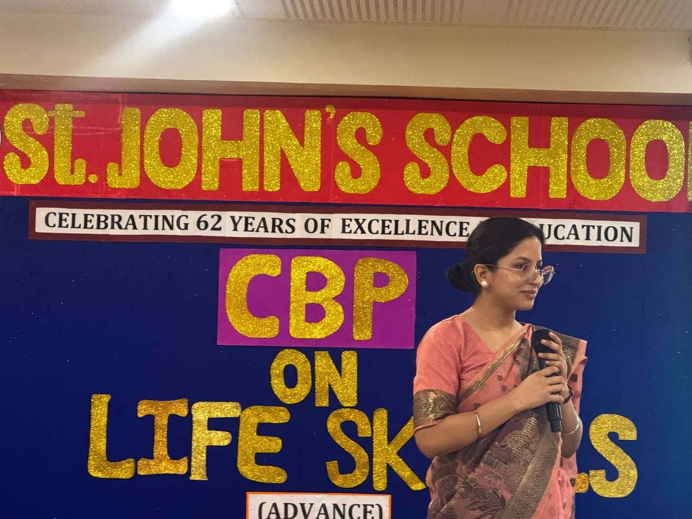 Lamhi speaking in front of the St. John's School Life Skills workshop banner